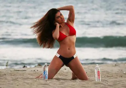 Shawna Craig posing with 138 Water bottles on the beach during 4th of July party in Malibu